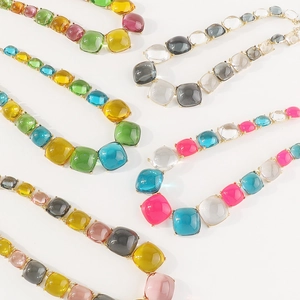 Détail des pierres en résine colorées taille coussin sur monture dorée pour collier bohème