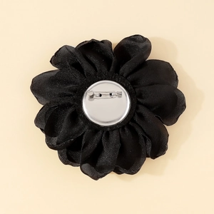 Detailed back view of a handmade black fabric rose brooch with a silver metal pin clasp