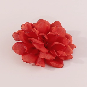 Detailed close-up of a handmade red fabric rose brooch with silk layers for garment decor