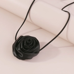 Close-up of a handmade black fabric rose choker with long satin ribbons for women