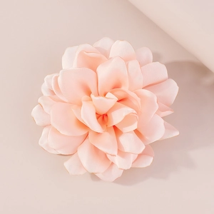 Close-up of peach pink handmade fabric rose brooch with elegant silk texture petals