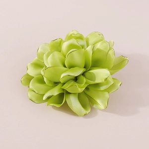 Detailed close-up of handmade green fabric flower brooch with elegant satin petals