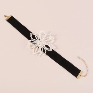 Detail of vintage black velvet choker with a large handmade white pearl flower ornament