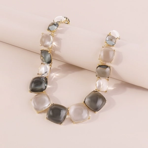 Détail du collier bohème géométrique en gelée avec pierres carrées et monture dorée élégante