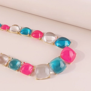 Détail macro d'un collier en résine colorée géométrique de style bohème doré