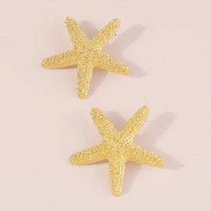 Detalle de pendientes de estrella de mar dorados con acabado metálico texturizado
