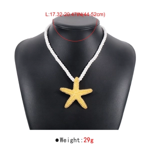 Détail du collier avec pendentif étoile de mer dorée texturée sur un mannequin d'exposition