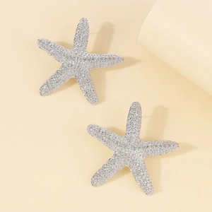 Vista detallada de pendientes de estrella de mar plateados con relieve metálico texturizado