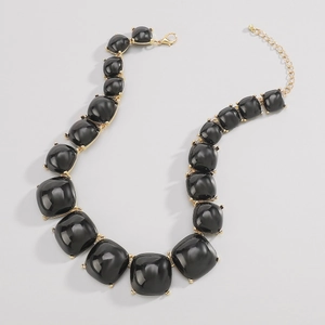 Détail du collier bohème à pierres noires carrées avec monture et fermoir dorés