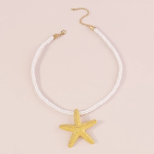 Detalle de colgante de estrella de mar amarilla en collar de cuerda blanca y cierre oro