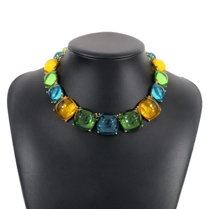 Vue macro d'un collier ras de cou en résine bohème avec des pierres colorées serties de griffes