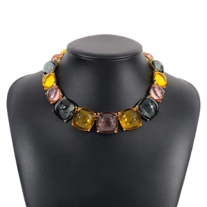 Détail du collier à gros maillons avec des gemmes carrées en résine colorée sur or