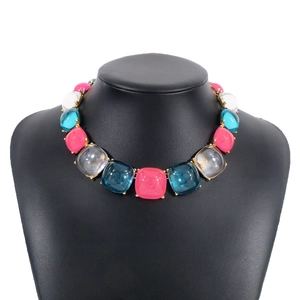 Détail du collier de perles en résine colorées avec des pierres carrées roses et bleues