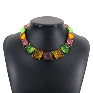 Détail d'un collier de pierres précieuses cabochon colorées sur un buste noir