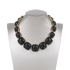 Détail du collier bohème géométrique avec carrés de résine noire et cadres dorés