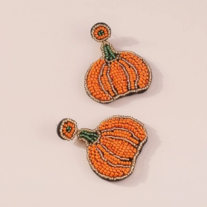 Detail van handgemaakte kralen oorbellen in pompoenvorm met oranje en goud accenten