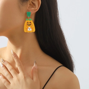 Detailopname van model met cartoon Halloween pompoen en spook hanger oorbellen