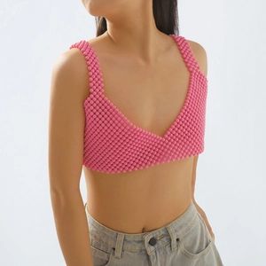 Detalle de crop top de cuentas acrílicas rosas con diseño artesanal de cuello en V
