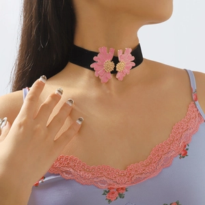 Close-up of pink enamel floral chokers with black velvet band and golden accents