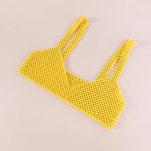 Vista detallada del crop top amarillo con cuentas acrílicas, malla y tirantes anchos