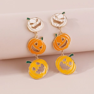 Detail van Halloween pompoen oorbellen met emaille gezichten op een beige standaard