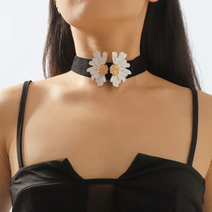 Detailed close-up of a black velvet choker featuring two white daisy flower pendants