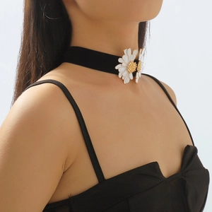 Close-up of black velvet choker with two white daisy charms and gold accents on model