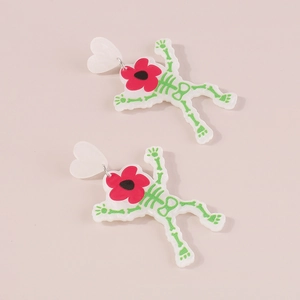 Detail van skelet oorbellen met groene botpatronen en rode bloemhoofdjes voor Halloween