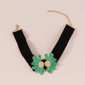 Close-up of black velvet choker featuring green enamel flowers and gold lobster clasp