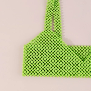 Detalle del tejido de cuentas acrílicas verdes hecho a mano en este chaleco de cadena