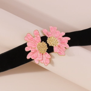 Detail of pink enamel flowers on black velvet choker with gold-edged petal textures