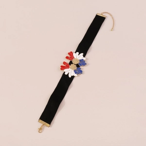 Detailed macro view of black velvet choker with three-color enamel flower pendants