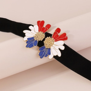 Macro view of velvet choker featuring vintage floral enamel charms with golden details