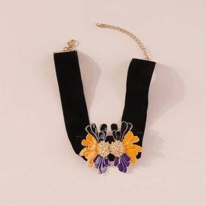 Detail of vintage velvet choker with orange and purple enamel flower charms and gold clasp