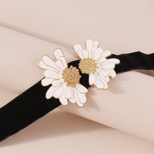 Detail of velvet choker with two white daisy flowers and golden metal bead centers