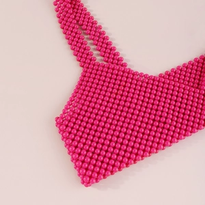 Primer plano del chaleco de cuentas rosa fucsia con textura detallada de cuentas de resina