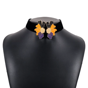 Detail of velvet choker featuring symmetrical orange and purple enamel flower petals