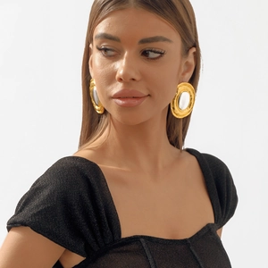 Detailed view of oversized vintage mixed-metal oval pendant necklace on a female model