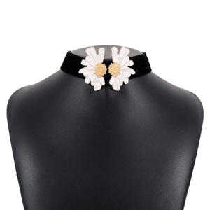 Close-up of black velvet choker featuring two white daisy flowers with gold centers