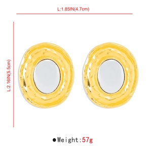 Detailed view of oversized oval gold earrings with white enamel inlay and wave borders