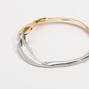 Dettaglio del bracciale bicolore con texture a lava e design in metallo fuso artistico
