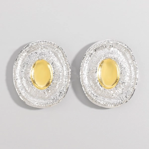 Detail of two-tone oval earrings featuring a textured silver border and polished gold center