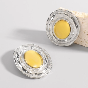 Detailed view of irregular hammer-textured dual-tone earrings with gold and silver finish