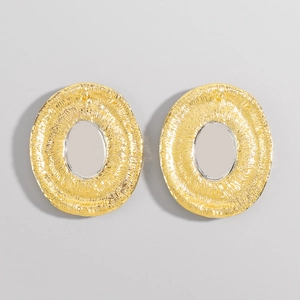 Detail of gold oval hoop earrings showing hammered texture and modern hollow design