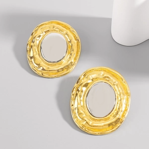Macro detail of gold hammered circular earrings with smooth silver mirror inlay