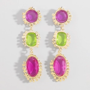 Vista detallada de pendientes largos retro dorados con gemas de resina de colores