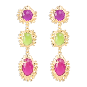 Detalle de pendientes de resina con acabado dorado martillado y gemas de colores