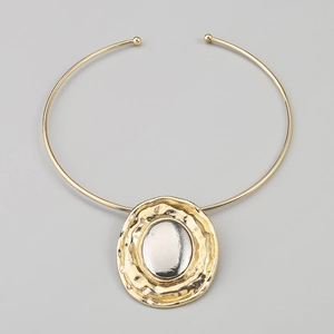 Detailed macro view of the gold hammered texture and silver mirror pendant necklace