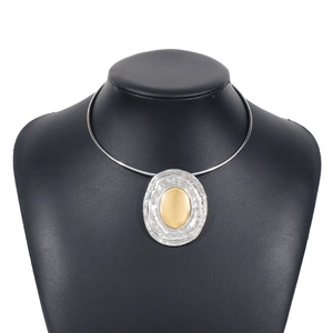 Detailed macro view of two-tone oval necklace with silver hammered texture and gold mirror center