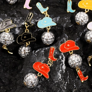 Detail of colorful enamel cowboy hat and boot earrings with shiny disco ball drops
